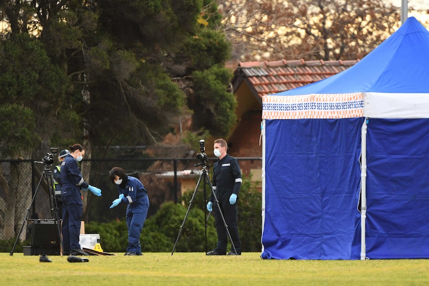 Victorian Police forensic officers at the scene where a woman's body was found on a soccer field in Melbourne's north.