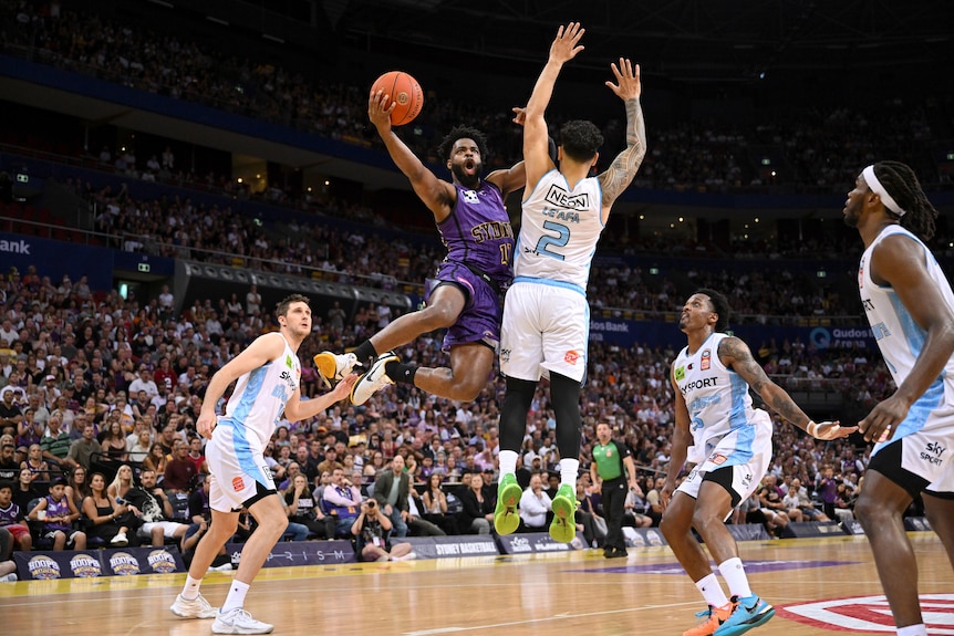 A Sydney Kings player takes to the air against New Zealand Breakers.