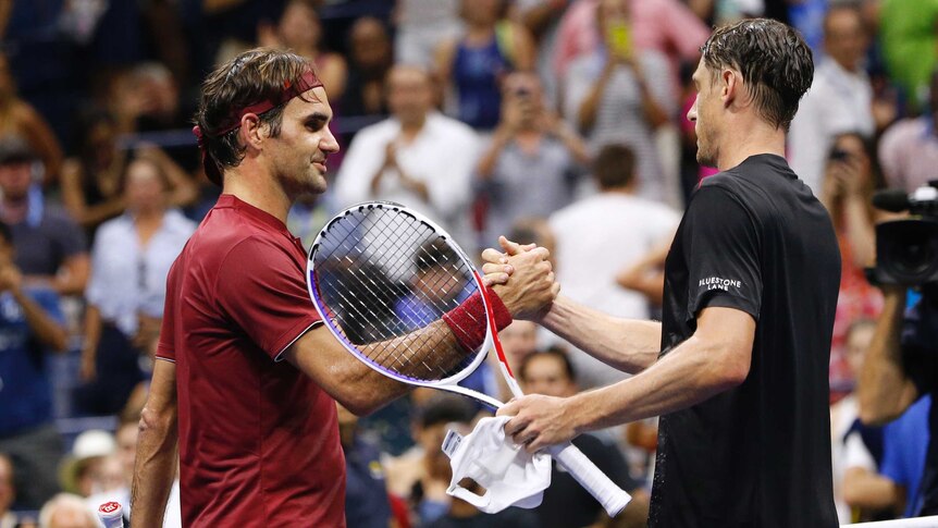 Roger Federer shakes hands with John Millman at the net.