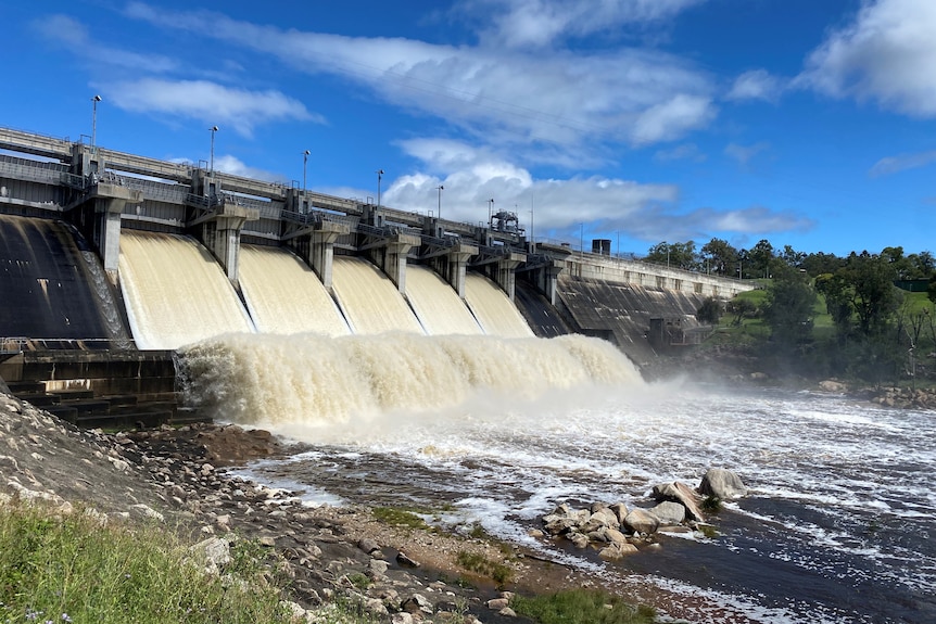 Montones de agua que fluyen a través de la presa.