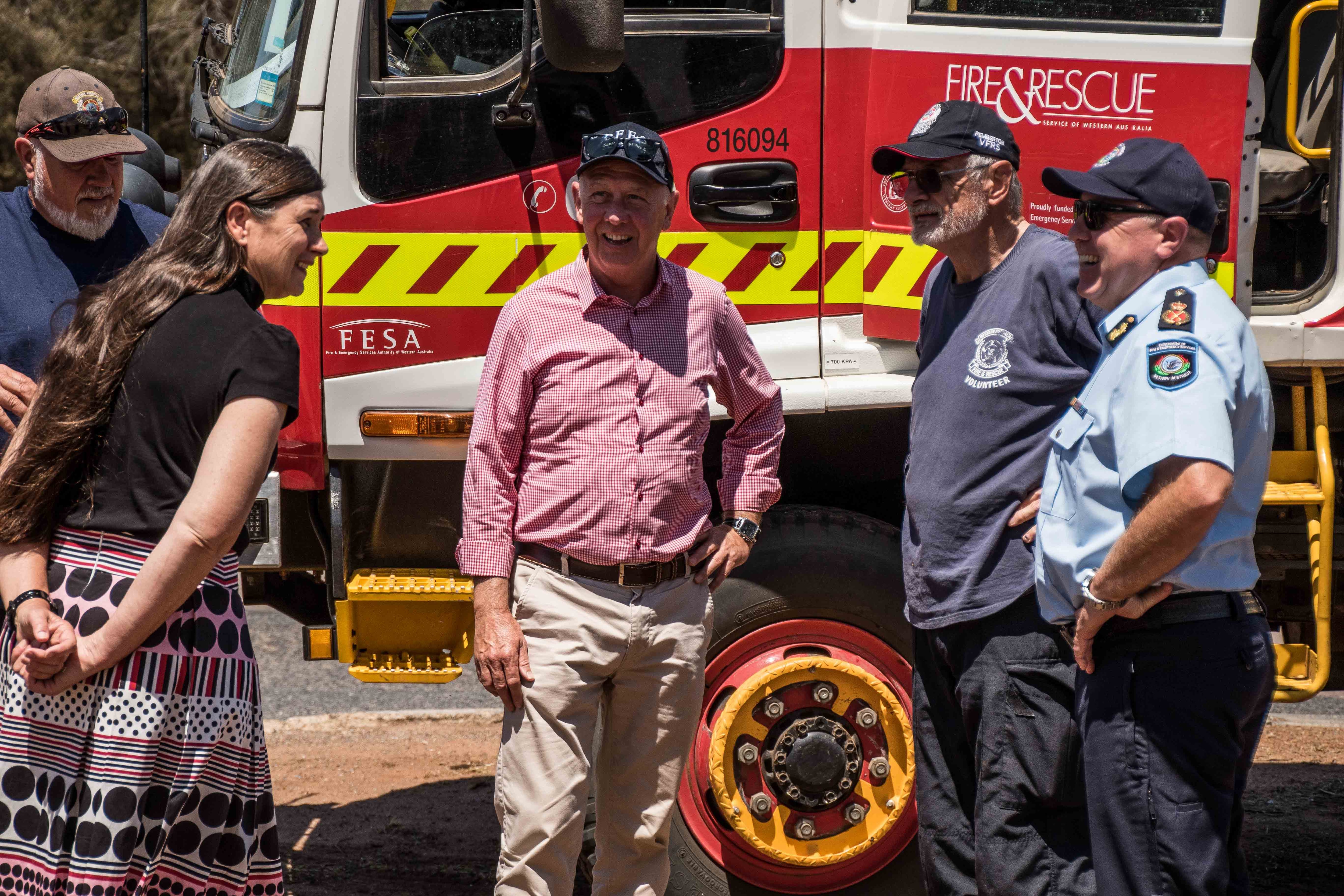 State politician standing in front of truck talking to volunteers