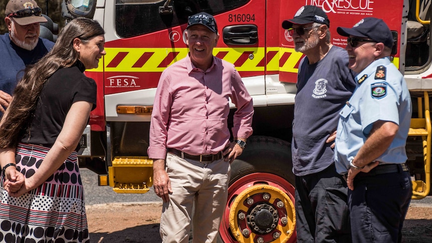 State politician standing in front of truck talking to volunteers