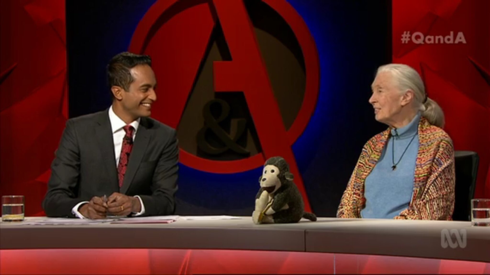 A man sits next to a woman with a toy monkey in front of them.