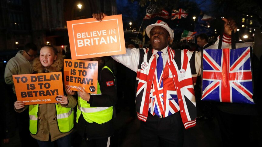 Pro-brexit supporters outside British parliament, holding signs