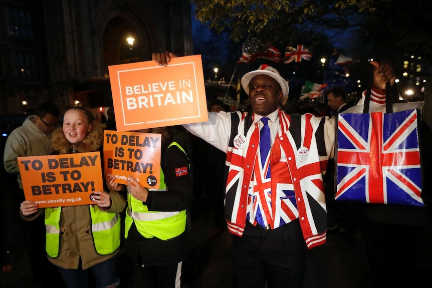 Pro-brexit supporters outside British parliament, holding signs