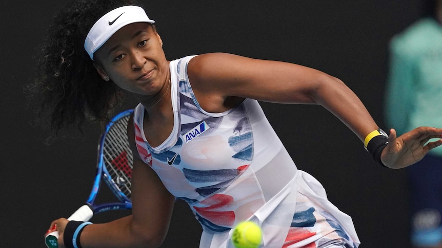 Naomi Osaka stares at the ball intently as she cocks her wrist for a forehand.