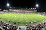 A wide image of a soccer stadium with filled stands.