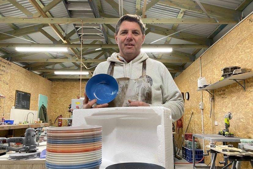 Brad Scott holds the plastic bowls he makes in this workshop.