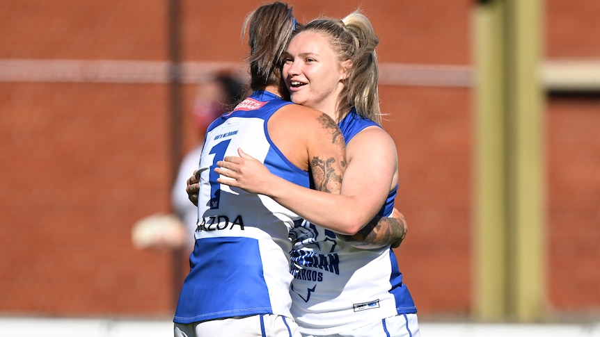 Two North Melbourne AFLW players embrace during the win over Fremantle.
