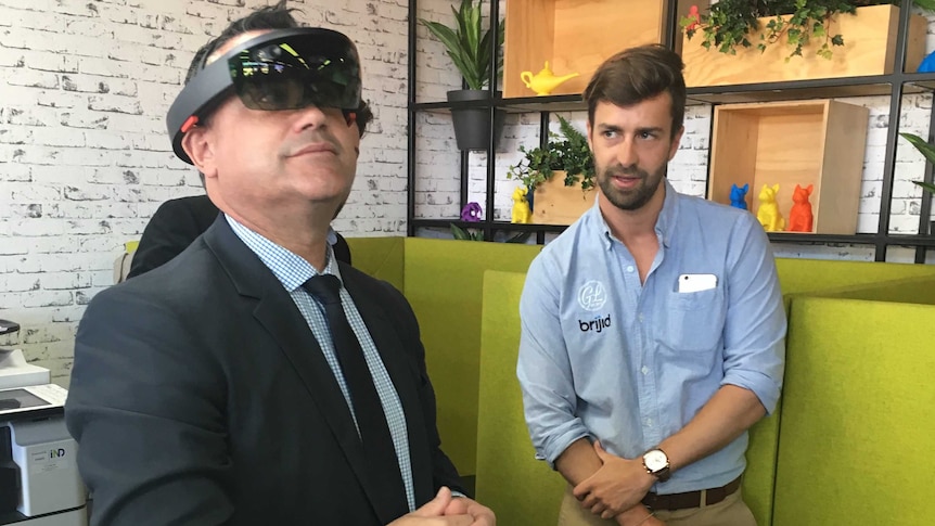 NSW Deputy Premier John Barilaro wears a virtual reality headset at an office.