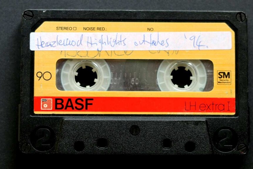 An image of a yellow cassette tape recorded by Justin Heazlewood as a child, titled 'Heazlewood Highlights outtakes '94'.