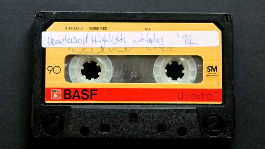 An image of a yellow cassette tape recorded by Justin Heazlewood as a child, titled 'Heazlewood Highlights outtakes '94'.