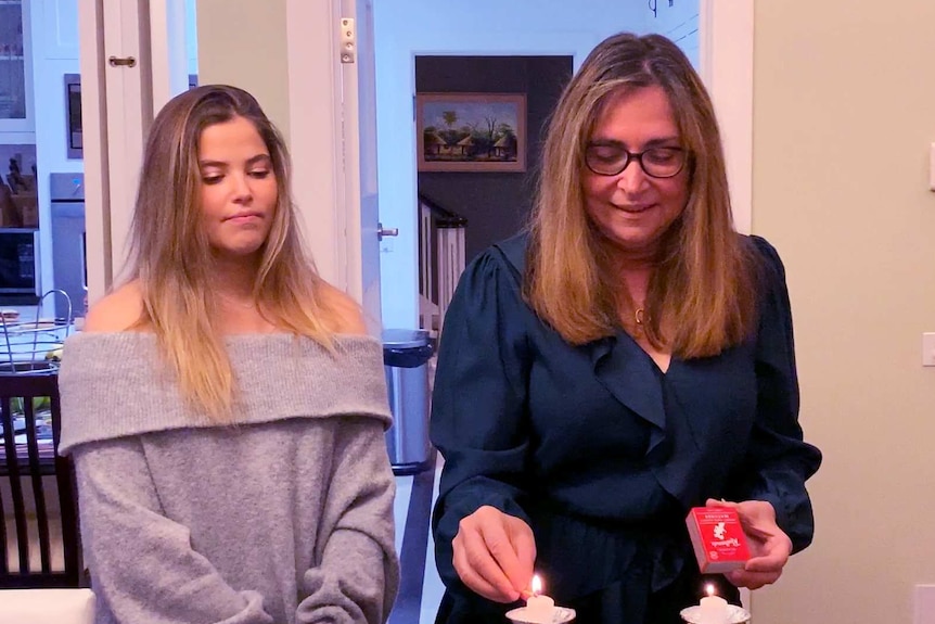 Tyla and mum Linda Chapman lighting candles in their home.