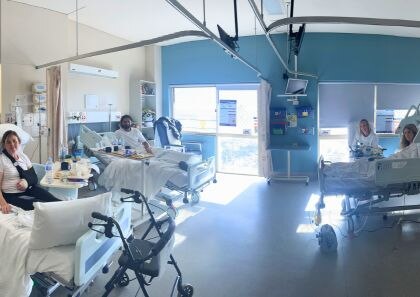 A hospital ward with multiple patients in beds 