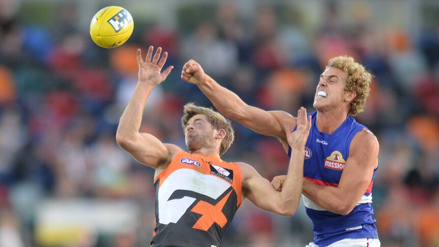 The Giants' Callan Ward fights for the ball with the Western Bulldogs' Mitch Wallis.