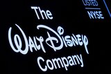 A screen shows the logo and a ticker symbol for The Walt Disney Company.