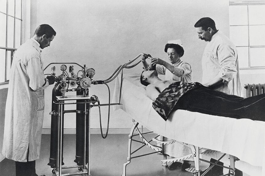 A patient receives anaesthesia, surrounded by two doctors and a nurse, 1902