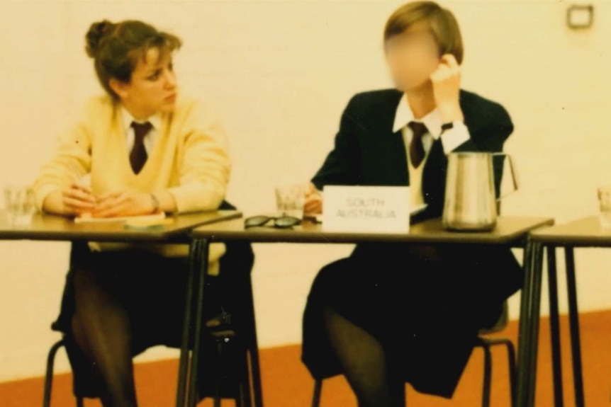 Jo Dyer and the woman sit at a desk in their school uniforms