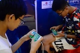 Young Chinese boys play games on their phones. 