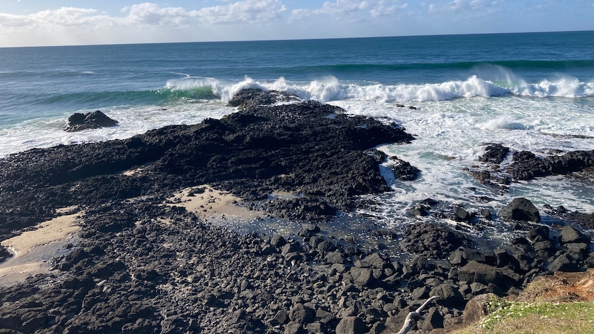 A wave break onto a rocky point.