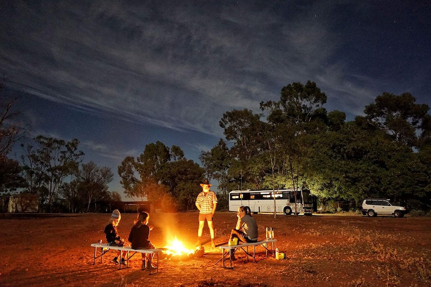 Keiran Lusk, his wife Sam and two sons enjoy a campfire after a day on the road in outback Queensland.