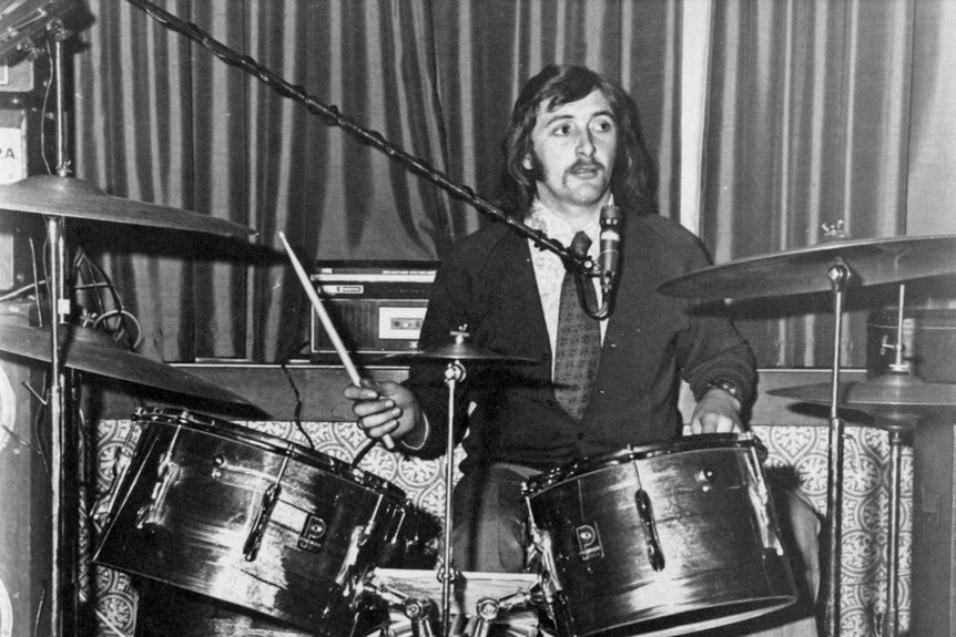 A black-and-white photo of Tom and Nick Wolfe's father, Malcolm, as a young man, playing the drums.