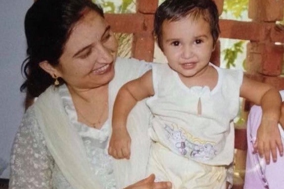 Nandini Sharma, pictured as a toddler, is held by her mother before migrating to Australia.