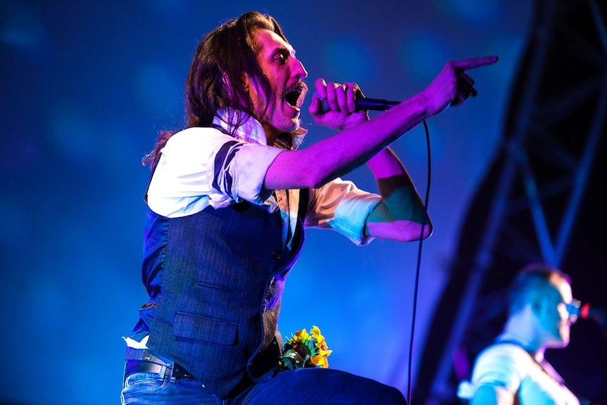 A singer from gypsy punk bank Gogol Bordello points at the crowd as he sings.