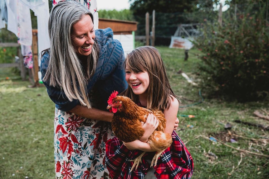 Ursula Wharton with her daughter who is holding a chicken.