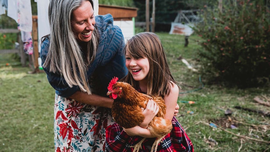 Ursula Wharton with her daughter who is holding a chicken.