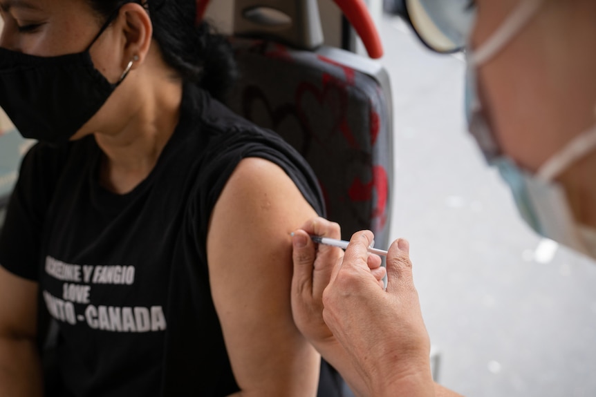 A woman receives a shot of the Pfizer/BioNTech vaccine.