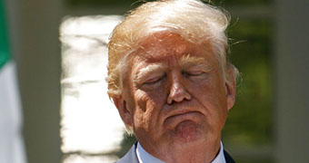 US President Donald Trump frowning with his eyes closed.