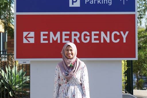 Woman standing in front of a hospital sign