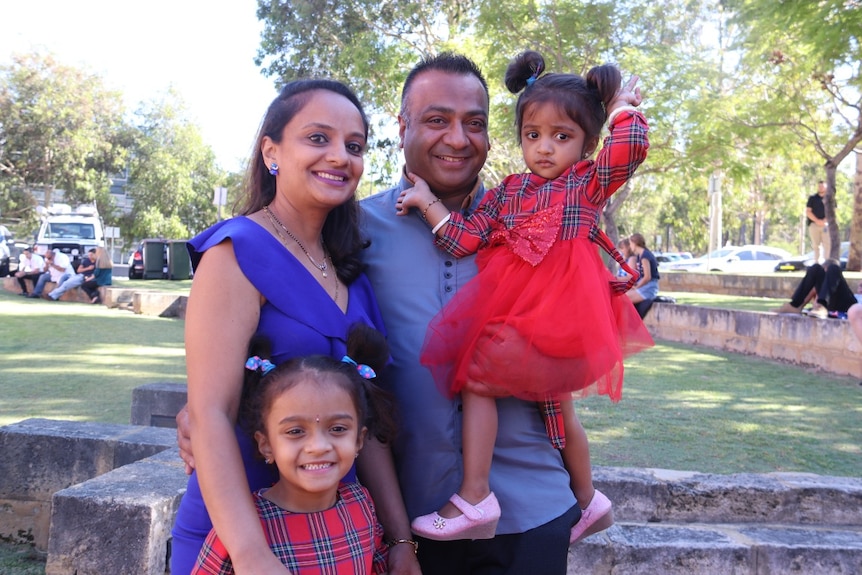 A couple with two young children in a park