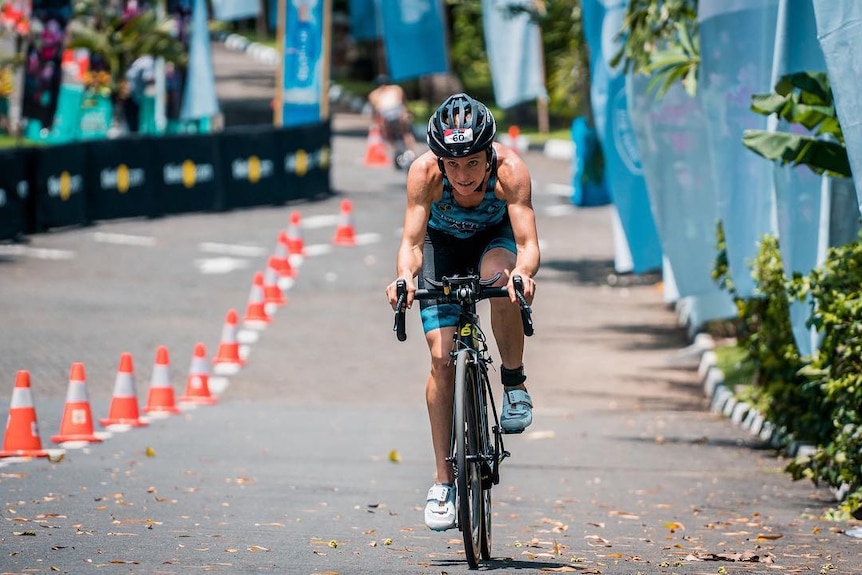 Woman riding a bike while competing in a triathlon event