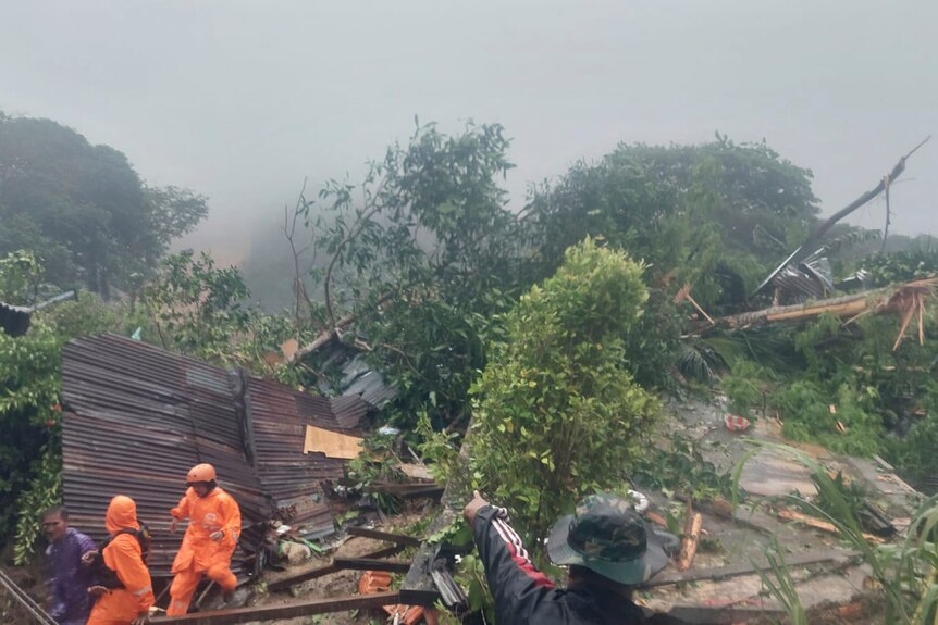 Rescuers search for victims at the site of a landslide.