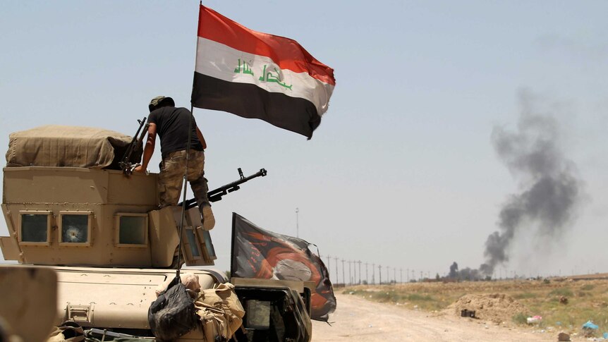 A member of the Iraqi security forces rides in a military vehicle on the outskirts of Fallujah.