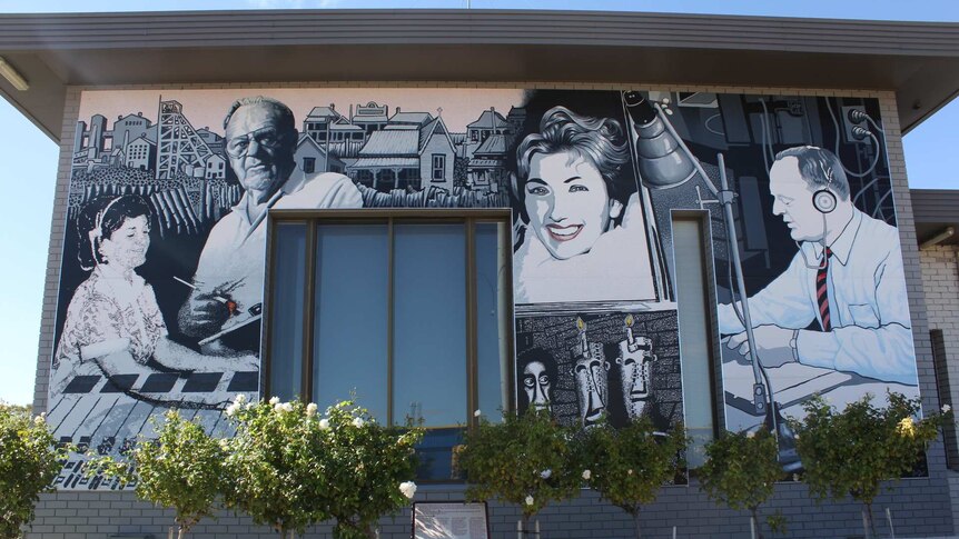A black and white mural of four people