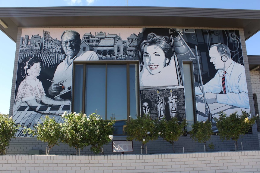 A black and white mural of four people