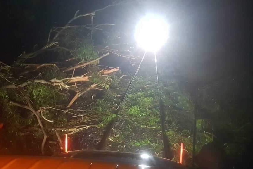 Storm debris on train tracks with a spotlight on them