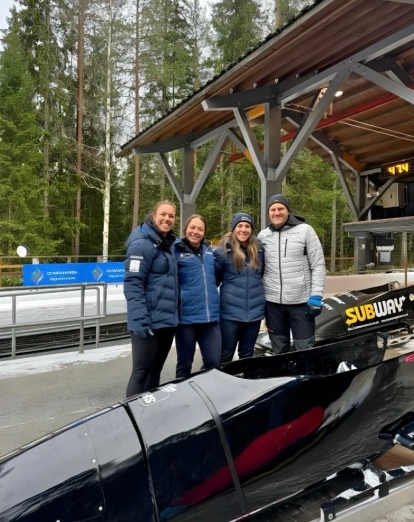 Kiara Reddingius Kristina Clonan and Bree Walker stand next to a bobsled