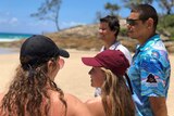 Four people looking at surf conditions at Adder Rock beach on North Stradbroke Island.