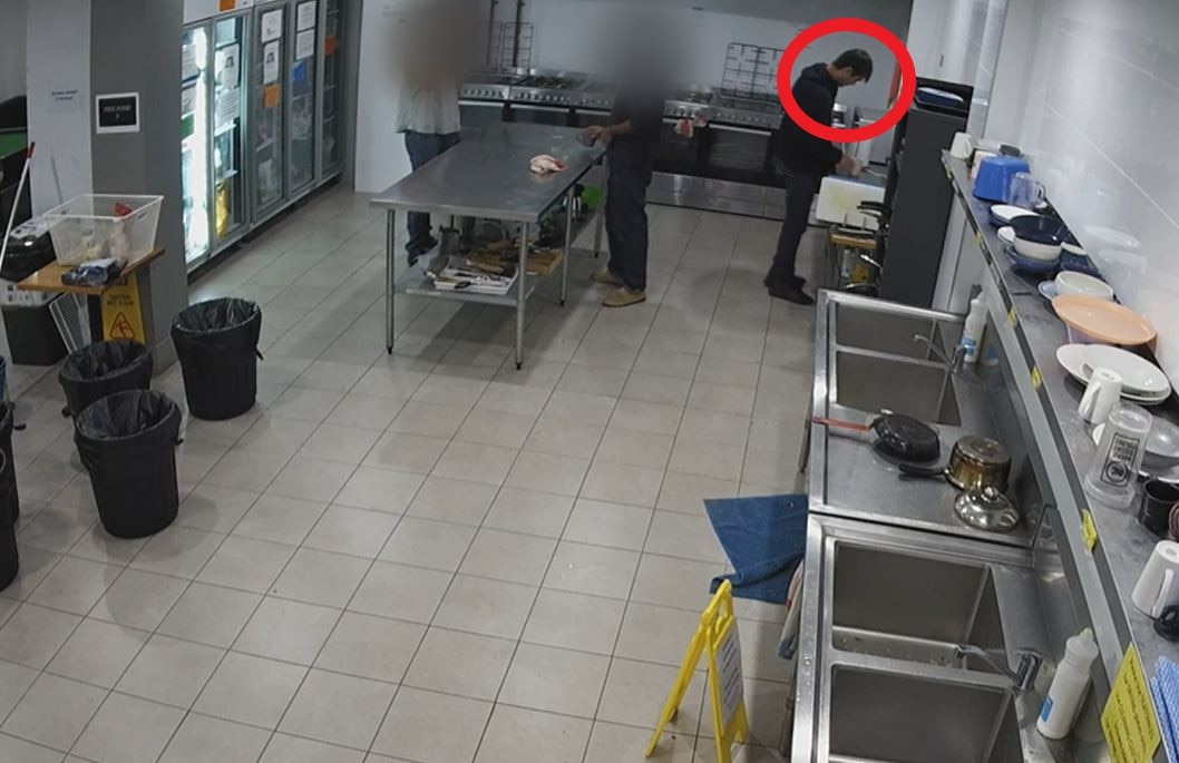 Three people standing in a kitchen, with one of them in a red digital circle. 