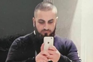 A man taking a selfie in a mirror with a smartphone camera.