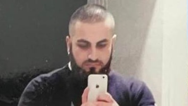 A man taking a selfie in a mirror with a smartphone camera.