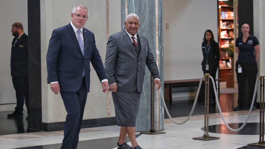 Australian Prime Minister Scott Morrison walks alongside Fijian Prime Minister Frank Bainimarama