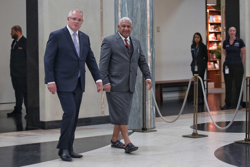 Australian Prime Minister Scott Morrison walks alongside Fijian Prime Minister Frank Bainimarama