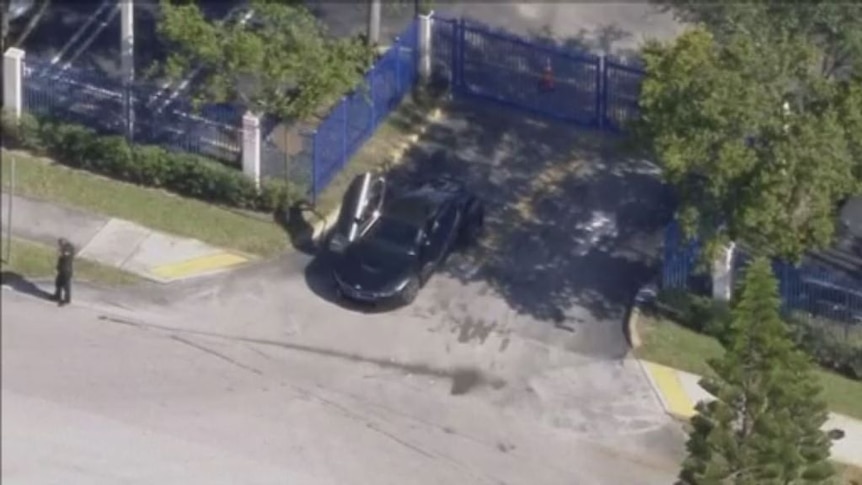 Aerial vision of the black vehicle parked near the motorcycle dealership.