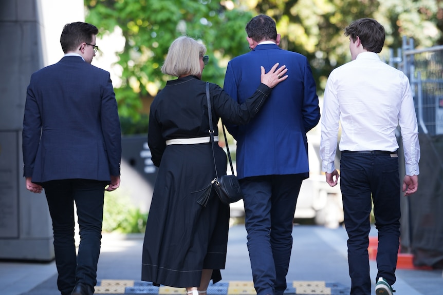 Daniel Andrews and his wife walk away from the camera with her hand on his back and his two sons either side of them.