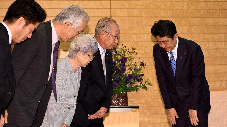 A group of Japanese people bowing to each other